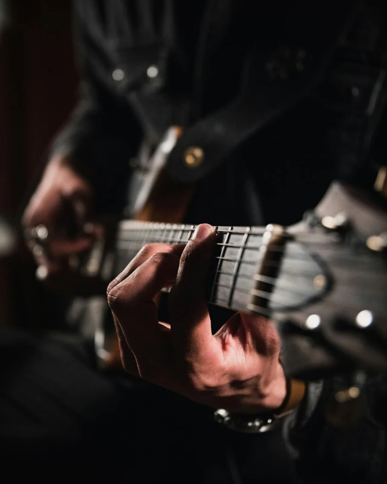 Guitariste en concert, gros plan sur le manche de la guitare