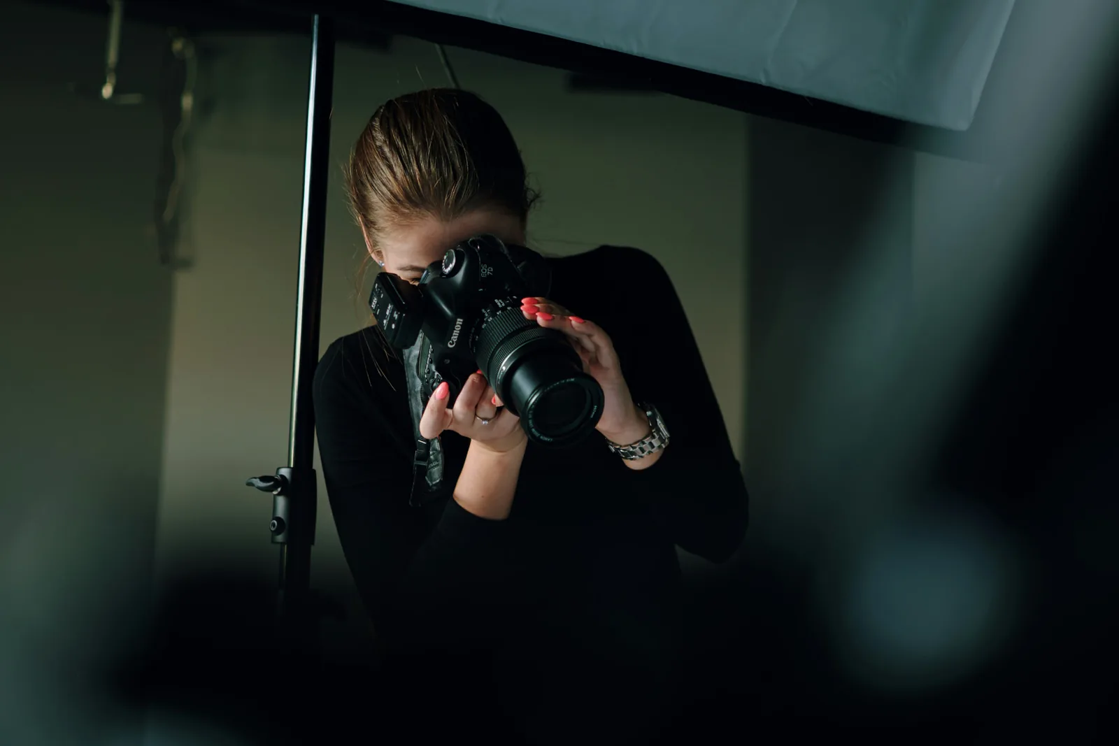 Photographe en studio derrière son appareil lors d'un shooting